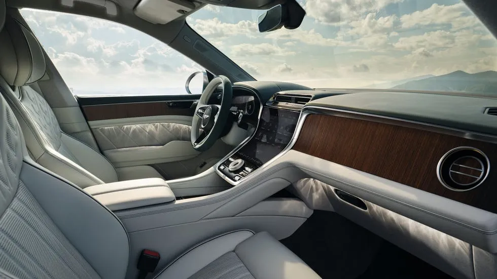 Luxurious car interior featuring light gray leather seats and elegant wood accents.