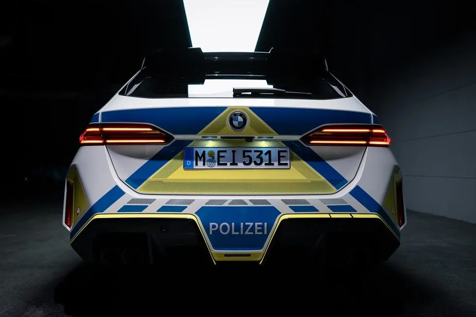 Rear view of a police car featuring distinctive blue and yellow markings and a license plate.