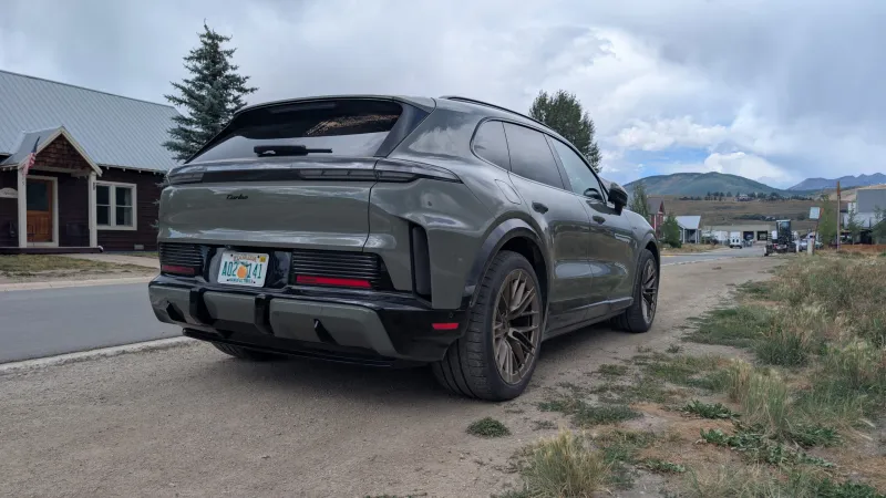 Черный Porsche Cayenne Turbo Electric в движении по извилистой трассе