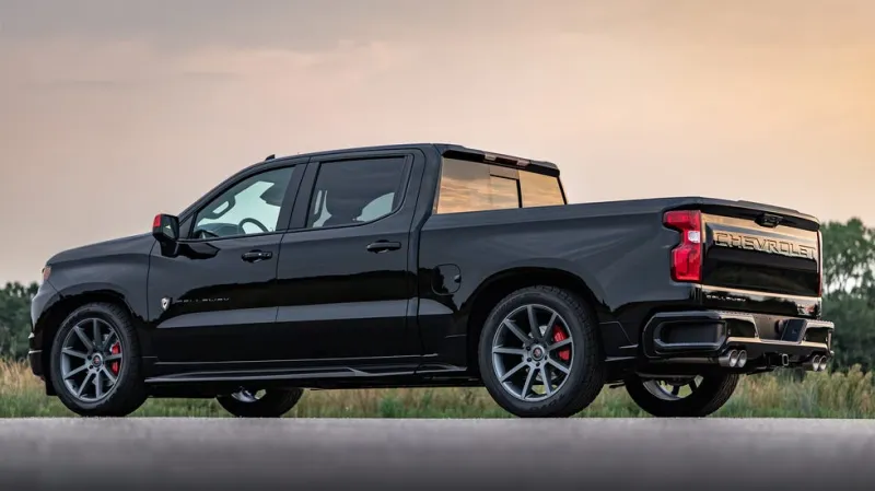 Грузовик Chevrolet Silverado с темным кузовом на живописном закатном пейзаже.